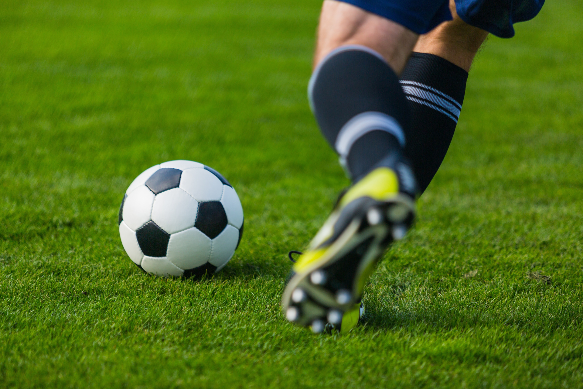 Ein Fuß, der gegen einen Fußball tritt 
© BillionPhotos.com - stock.adob